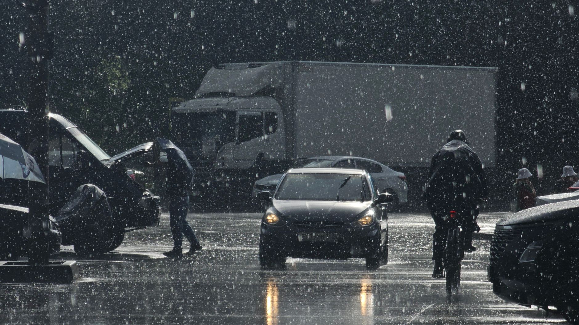 view of cars and pedestrians on the street in rain